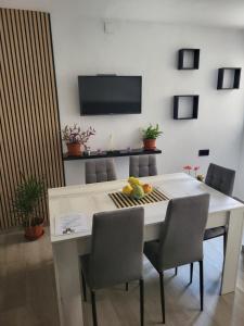 a dining room table with chairs and a television on the wall at Apartamento La Avenida in Lanjarón
