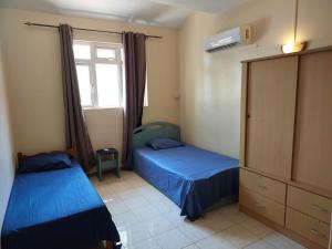 two beds in a room with a window at 3-Bedroom Duplex, Residence Bayview, Flic-en-Flac in Flic-en-Flac +56 photos