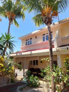 a house with palm trees in front of it at 3-Bedroom Duplex, Residence Bayview, Flic-en-Flac in Flic-en-Flac
