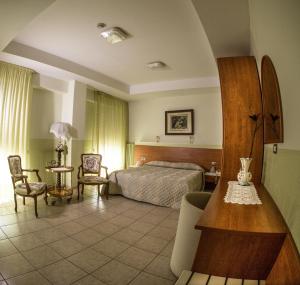 Tourist Hotel في بوتنزا: غرفة نوم بسرير وطاولة وكراسي