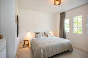 Jan ThielにあるDushi Tropicana, Jan Thiel, Curaçaoの大きなベッドと窓のある白い寝室