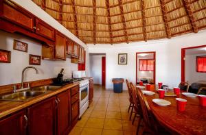 a kitchen with a sink and a table with chairs at Short walk to pool and private beach in Don Pancho