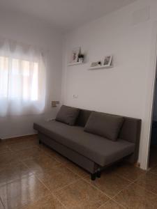 a couch in a living room with a window at El Mirador in Chiclana de Segura