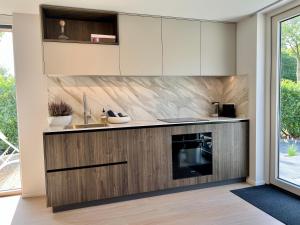 a kitchen with white cabinets and a sink at Juliette Domburg in Domburg