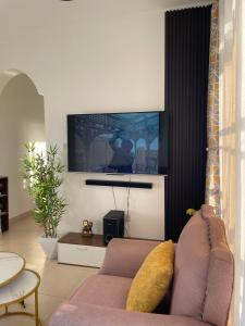 Una sala de estar con un sofá y un televisor de pantalla plana. en Molly apartment, en Mombasa