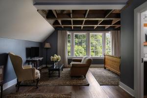 a living room with blue walls and windows at The NuWray Hotel & Carriage House in Burnsville