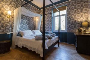a bedroom with a canopy bed and a window at La casa di K i p l i n g "charme coloniale & storia" in Gorizia
