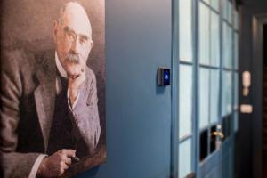 a painting of a man in a suit next to a door at La casa di K i p l i n g "charme coloniale & storia" in Gorizia