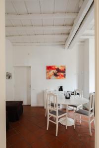une salle à manger blanche avec une table et des chaises blanches dans l'établissement Casa Mandes Spanish Steps, à Rome