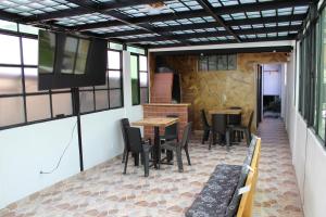 a patio with tables and chairs and a television at Hostel Mirador Aukán in Bogotá