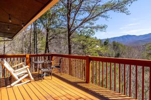 a wooden deck with a table and chairs on it at Relax, Play & Enjoy Mountain Views and Hot Tub in Pittman Center