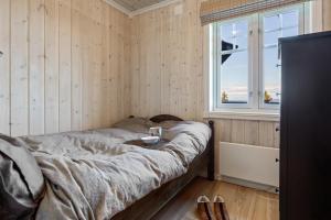 una camera da letto con un letto e una finestra di HYTTEEVENTYR I VALDRES MED JACUZZI, 5 soverom, alpinbakke og skiløyper like ved! ad Aurdal Altre 19 foto