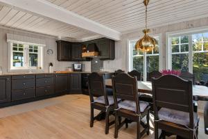 una cucina e una sala da pranzo con tavolo e sedie di HYTTEEVENTYR I VALDRES MED JACUZZI, 5 soverom, alpinbakke og skiløyper like ved! ad Aurdal