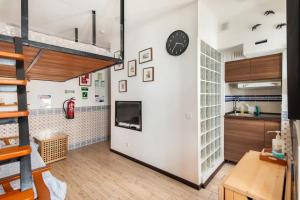a kitchen with a large white wall with a clock at Estudio T41 - Downtown Lisbon Historic Center in Lisbon