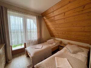 sypialnia z dwoma łóżkami i oknem w obiekcie Apartamenty Bukowina w Bukowinie Tatrzańskiej
