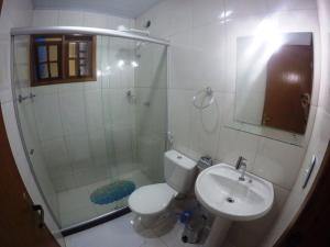 a bathroom with a shower and a toilet and a sink at Suítes do Cid in Abraão