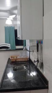 a kitchen with a sink and a counter top at Suítes do Cid in Abraão