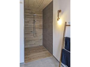 a shower in a bathroom with a wooden wall at Holiday home Chalet 48 in Mayen +14 photos