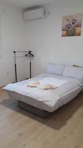 ein weißes Bett in einem Zimmer mit einem Gemälde an der Wand in der Unterkunft Komforna Soba U Centru #3 in Mladenovac