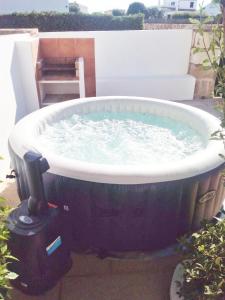 a large bath tub filled with water on a patio at Apartamento con terraza y jacuzzi, zona ciutadella in Cala en Blanes