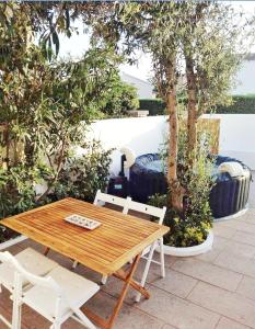 a wooden table and two chairs sitting next to a tree at Apartamento con terraza y jacuzzi, zona ciutadella in Cala en Blanes