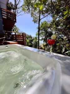 eine Badewanne mit einem Glas Wein darin in der Unterkunft Double Deck - Linda vista para ilha de Floripa com Jacuzzi in Palhoça
