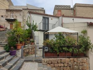Casa con balcón con plantas y sombrilla en La Furca Affitti Brevi, en San Cataldo