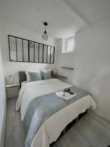 a white bedroom with a large bed in it at Le Loft de l'Artiste in Sèvres