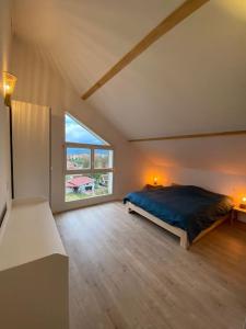 a large bedroom with a bed and a large window at LA MAISON DES VOSGES Nature & Pool in Senones