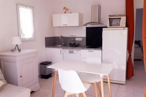 VelleronにあるNice flat with jacuzzi and gardenの白いテーブルと椅子のある白いキッチン