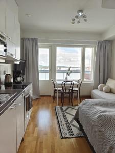 Una cocina y una sala de estar con mesa y sillas. en Sunstar Apartments, en Rovaniemi