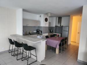 a kitchen with a table with chairs and a counter top at RESIDENCE ALPES in Annecy-le-Vieux