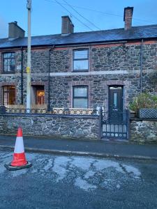 a stone house with a traffic cone in front of it at Snowdonia Quarryman cottage in Llanberis
