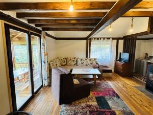 a living room with a couch and a table at Log cabin in Sejdanovići
