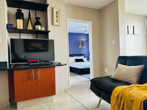 a living room with a television and a couch at Boulevard 208 in Margate