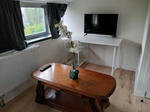 a room with a table with a remote control on it at Flat at Relegem in Asse
