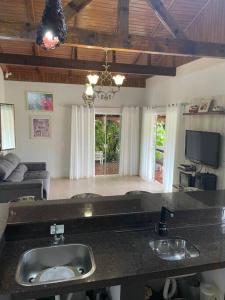 a kitchen with two sinks and a living room at Casa do Campo in Rio do Sul