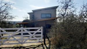 una casa con una valla blanca delante en Siu Kiu - Casa de Montaña, en El Parador