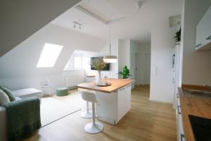 a kitchen and living room with a table and a couch at Kö27 - Modernes City-Apartment in Siegen