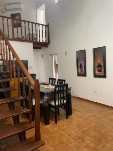 a dining room with a table and chairs and a staircase at Departamento A&F I planta baja in San Fernando del Valle de Catamarca