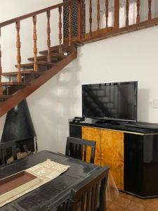 a living room with a table and a television and a staircase at Departamento A&F I planta baja in San Fernando del Valle de Catamarca +12 photos