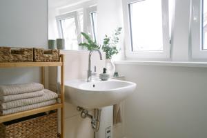 a bathroom with a white sink and a mirror at Kö27 - Modernes City-Apartment in Siegen +27 photos