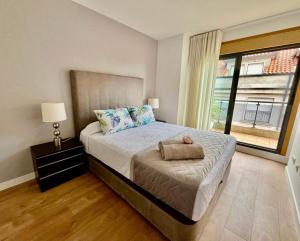 Un dormitorio con una cama con un osito de peluche encima. en Precioso ático con amplia terraza, en Portonovo 11 fotos más