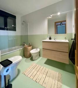 ein Badezimmer mit Toilette, Waschbecken und Spiegel in der Unterkunft THE PLACE - surf & soul in Majanicho