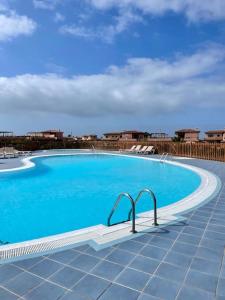 ein großer blauer Pool in einem Gebäude in der Unterkunft THE PLACE - surf & soul in Majanicho