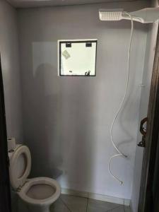 a bathroom with a white toilet and a shower at Casa da lagoa in Barra do Trombudo