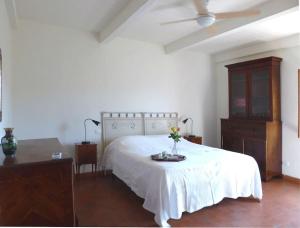 a bedroom with a white bed and a table with flowers on it at Podere Solatio - Tuscany Hills next to Florence in Impruneta +28 photos