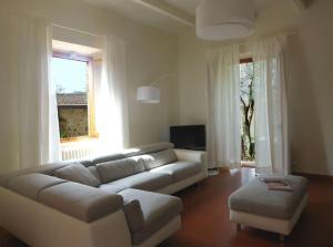 a living room with a white couch and a large window at Podere Solatio - Tuscany Hills next to Florence in Impruneta