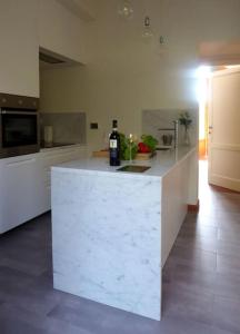 a kitchen with a white counter with a bottle of wine at Podere Solatio - Tuscany Hills next to Florence in Impruneta