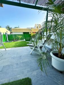 a patio with two white chairs and a plant at Bungalow Yaipe in Maspalomas